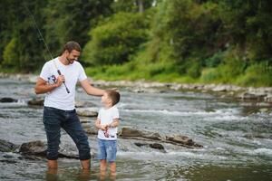 Vater und Sohn Angeln. Vater mit seine Sohn auf das Fluss genießen Angeln halten Angeln Stangen foto