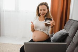 selektiv Fokus von heiter schwanger Frau zeigen Ultraschall Fotos während haben Video Anruf