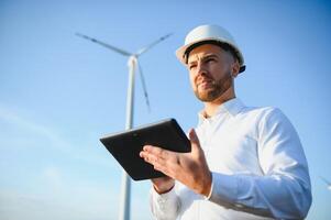 elektrisch Ingenieure Arbeiten beim Wind Turbine Leistung Generator Bahnhof mit Laptop Computer foto