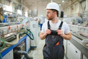 Fabrik Arbeiter. Mann Arbeiten auf das Produktion Linie foto