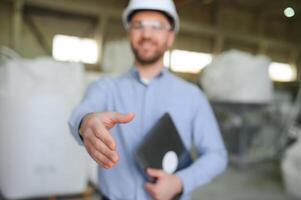 Porträt von zuversichtlich gut aussehend technisch Ingenieur im Bauarbeiterhelm. foto