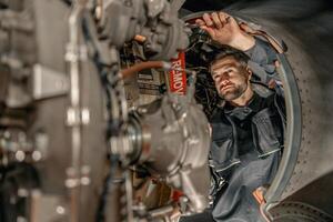 bärtig Mann Mechaniker reparieren Flugzeug im Halle foto