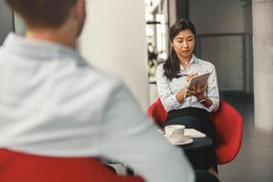 weiblich Std Manager suchen auf Digital Tablette während Interview mit Job Kandidat im Büro foto