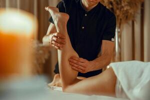 männlich Therapeut tun Fachmann Bein Massage zum weiblich Klient beim Spa Center foto