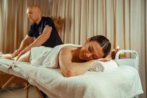 Frau Lügen mit Augen geschlossen, genießen Fachmann Massage beim Spa Center foto