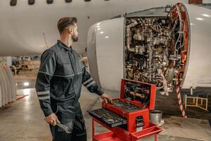 männlich Flugzeug Mechaniker mit Werkzeug Box im Halle foto