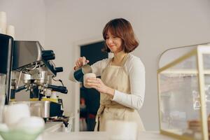 ziemlich weiblich Barista macht Kaffee und gießt es in ein Becher während Arbeiten im Kaffee Geschäft foto