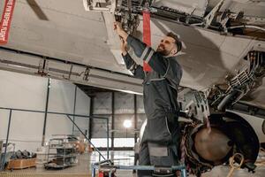 heiter männlich Mechaniker reparieren Flugzeug beim Reparatur Bahnhof foto