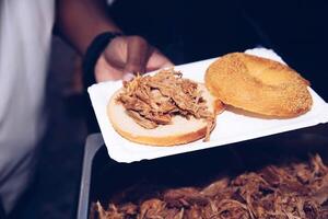 Nahansicht von gezogen Schweinefleisch Sandwich Vorbereitung auf Teller foto