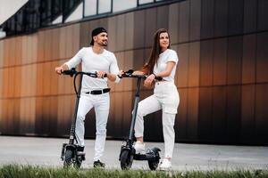 ein Paar auf elektrisch Roller Reiten um das Stadt, ein Paar im Liebe auf Roller foto