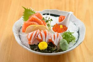 japanisch Essen Sashimi Shake Teller mit Eis im ein Schüssel isoliert auf hölzern Hintergrund oben Aussicht foto