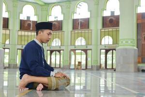 Porträt von religiös asiatisch Mann im Muslim Hemd beten und tun salat oder sholat im Moschee foto