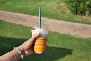 Hand halten ein trinken mit ein Stroh im ein Plastik Tasse foto