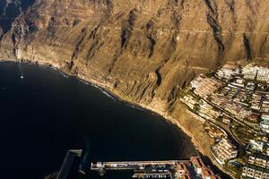 oben Aussicht von das Häuser gelegen auf das Felsen von los Giganten beim Sonnenuntergang, Teneriffa, Kanarienvogel Inseln, Spanien foto