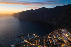 oben Aussicht von das Häuser gelegen auf das Felsen von los Giganten beim Sonnenuntergang, Teneriffa, Kanarienvogel Inseln, Spanien foto