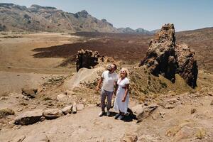 ein verheiratet Paar ist Stehen im das Krater von das teide Vulkan. Wüste Landschaft im Teneriffa. teide National Park. Teneriffa, Spanien foto