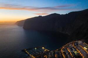 oben Aussicht von das Häuser gelegen auf das Felsen von los Giganten beim Sonnenuntergang, Teneriffa, Kanarienvogel Inseln, Spanien foto