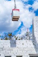 Konstruktion Kran mit Blöcke im Vorderseite von Blau Himmel. Gebäude hoch Wohn Gebäude. foto