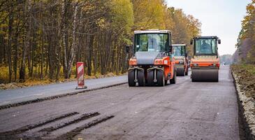 Straße Walze Abflachung Neu Asphalt. schwer Vibration Walze beim Arbeit Pflasterung Asphalt, Straße reparieren. selektiv Fokus. foto