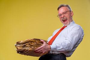 Stapel von Unterlagen im Hände. Senior Mann holdind Haufen von Unterlagen Papier arbeiten. überrascht von schwer mental Arbeit foto