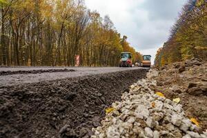 schließen Aussicht auf das Straße reparieren. Walze Arbeiten auf das Neu Straße Konstruktion Seite? ˅ foto