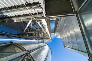 Wird geladen Einrichtung Gebäude Außen. niedrig Winkel Aussicht von das Panzer und landwirtschaftlich Silos von Korn Aufzug Lagerung. Aussicht von unter. foto