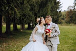 ein Hochzeit Paar ist Gehen im Natur auf ein Herbst Tag. glücklich jung Braut und elegant Bräutigam halten Hände. ein stilvoll Paar von Jungvermählten auf ihr Hochzeit Tag. foto