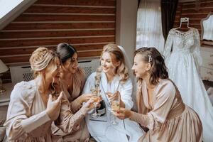 Foto mit Brautjungfern Trinken Champagner von Brille im das Morgen im ein schön Hotel. Foto von ein schön jung Braut und ihr freunde im passend Kleider Trinken Champagner Vor das Hochzeit.