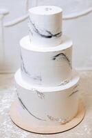 ein groß luxuriös mehrstufig Hochzeit Kuchen im das Bankett Halle. Hochzeit Dessert unter das Abend Licht. Hochzeit Dekor. foto