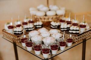 Mandel Kekse, Süss Kuchen zum ein Hochzeit Bankett. ein köstlich Rezeption, ein luxuriös Zeremonie. Tabelle mit Süßigkeiten und Nachspeisen. köstlich bunt Französisch Nachspeisen auf ein Teller oder Tisch. Süßigkeiten Bar. foto