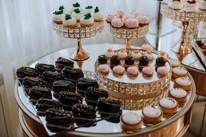 Mandel Kekse, Süss Kuchen zum ein Hochzeit Bankett. ein köstlich Rezeption, ein luxuriös Zeremonie. Tabelle mit Süßigkeiten und Nachspeisen. köstlich bunt Französisch Nachspeisen auf ein Teller oder Tisch. Süßigkeiten Bar. foto