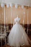 Schlafzimmer Innere mit Hochzeit Kleid bereit zum das Zeremonie. ein schön üppig Hochzeit Kleid auf ein Mannequin im ein Hotel Zimmer. foto