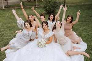 Hochzeit Fotografie. ein Brünette Braut im ein Weiß Kleid mit ein Strauß und ihr Brünette Freundinnen foto