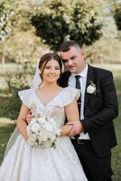 stilvoll, jung Bräutigam und schön Braut im ein lange Weiß Kleid und ein lange Schleier mit ein Strauß im ihr Hände, umarmen im das Park im das Herbst Natur. Hochzeit Porträt von Jungvermählten. foto