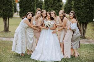 Hochzeit Fotografie. ein Brünette Braut im ein Weiß Kleid mit ein Strauß und ihr Brünette Freundinnen foto