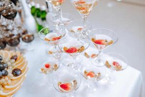 ein Stand zum ein Champagner Glas beim ein Hochzeit. Brille zum alkoholisch Getränke im Vorderseite von das Eingang zu das Bankett Halle. Alkohol. Champagner. Feier. foto