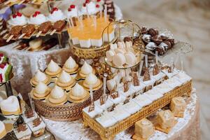 Mandel Kekse, Süss Kuchen zum ein Hochzeit Bankett. ein köstlich Rezeption, ein luxuriös Zeremonie. Tabelle mit Süßigkeiten und Nachspeisen. köstlich bunt Französisch Nachspeisen auf ein Teller oder Tisch. Süßigkeiten Bar. foto