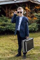 ein wenig Junge imitiert ein Geschäftsmann. foto