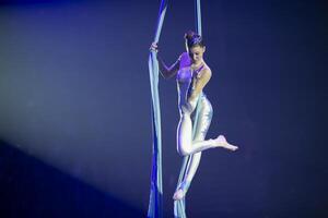 Performance durch ein Zirkus Akrobat Künstler. Mädchen ausführen Antenne akrobatisch Elemente auf Stoff. foto