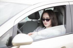 jung Mädchen im Sonnenbrille im das Wagen. schön Frau Fahren foto