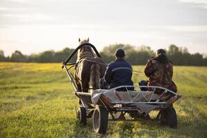 das Dorfbewohner sind Sitzung auf ein Wagen mit ein Pferd. foto