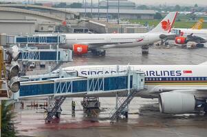 Landschaft von Terminal 2 von Juanda International Flughafen welche ist ausgestattet mit ein modern Einsteigen Brücke mit mehrere Flugzeuge geparkt auf das Schürze, Indonesien, 6 Januar 2024 foto