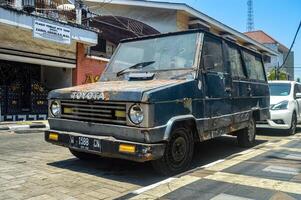 ein uralt und Stumpf Toyota kijang Auto geparkt auf das Seite von das alt Stadt Straße, Indonesien, 17 September 2023. foto