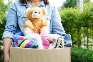 Freiwillige sammeln Stoff und Puppe im Karton Box zu spenden. foto