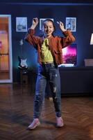 Beliebt Kind nimmt Teil im viral tanzen Trend nach Sehen Liebling Prominente tun Es, filmen Familie Kanal Video im Wohnung zum Kinder Publikum. lächelnd Kind tut modisch Tanzen Herausforderung foto