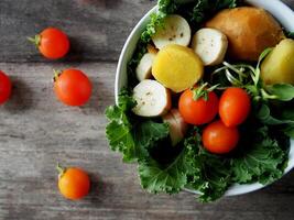 bunt Gemüse Salat auf Holz Tabelle Grünkohl und Sonnenblume sprießen foto