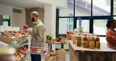 Klient suchen beim bio Früchte und Gemüse im Kisten, Kauf organisch frisch geerntet Gemüse zu Koch vegan Mahlzeit. jung Erwachsene im lokal Öko freundlich Supermarkt sucht zum Chemikalien kostenlos Lebensmittel. foto