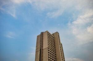 ein alt Wolkenkratzer oder Wohnung Das sieht aus Stumpf gegen ein Blau Himmel Hintergrund foto