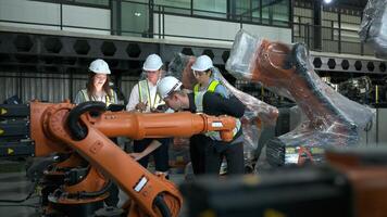 Gruppe von Ingenieure und Techniker Arbeiten zusammen im ein Roboter Arm Fabrik. inspizieren Roboter Arm Vor liefern zu Kunden foto