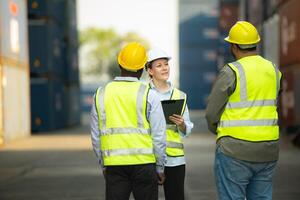 Gruppe von Ingenieure Arbeiten mit Laptop im das Container Hof. diese ist ein Fracht Transport und Verteilung Lagerhaus. foto